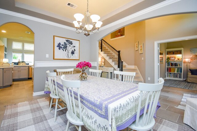 5006 Isidore Ln, Missouri City, TX 77459 - dining area with arched walkways, stairs, a tray ceiling, a chandelier, and ornamental molding