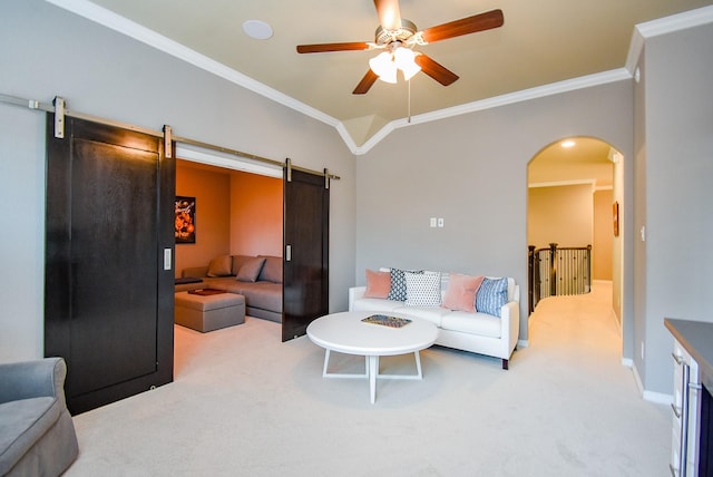 5006 Isidore Ln, Missouri City, TX 77459 - carpeted living room with a barn door, ornamental molding, arched walkways, a ceiling fan, and baseboards