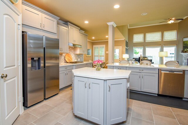 5006 Isidore Ln, Missouri City, TX 77459 - kitchen featuring appliances with stainless steel finishes, a sink, light countertops, under cabinet range hood, and light tile patterned floors