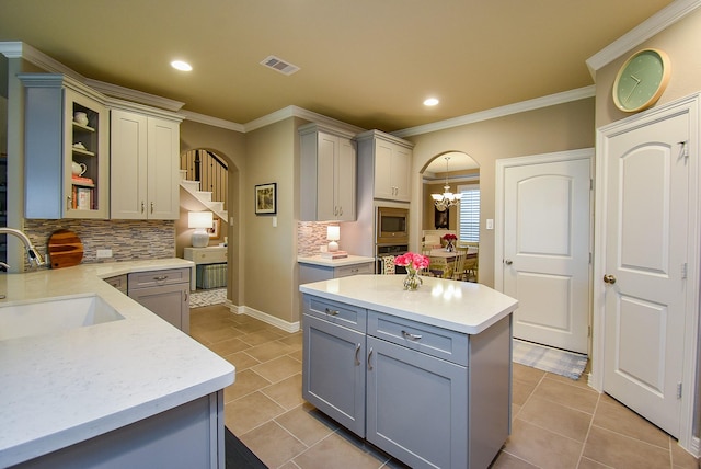 5006 Isidore Ln, Missouri City, TX 77459 - kitchen featuring gray cabinets, a sink, decorative backsplash, ornamental molding, and light tile patterned flooring