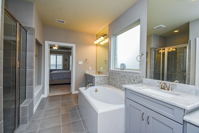 5006 Isidore Ln, Missouri City, TX 77459 - ensuite bathroom featuring tile patterned flooring, a stall shower, a bath, two vanities, and a ceiling fan