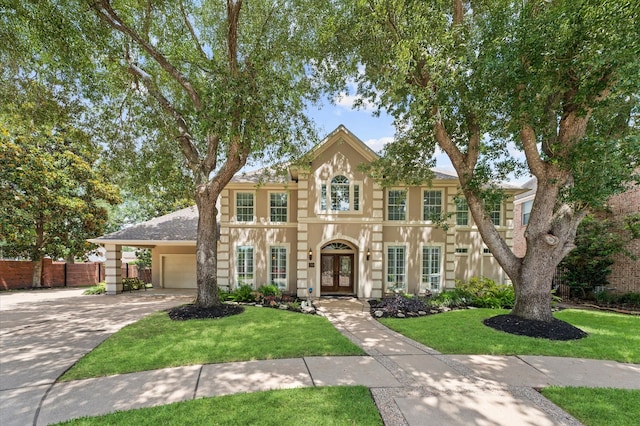 view of front of home featuring french doors, a garage, concrete driveway, and stucco siding