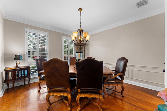 dining space featuring a chandelier, ornamental molding, and hardwood / wood-style floors