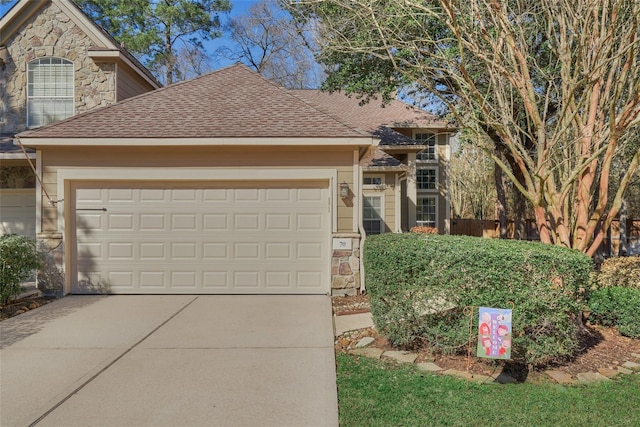 70 Harvest Wind Pl, The Woodlands, TX 77382 - view of front facade featuring stone siding, a garage, concrete driveway, and a shingled roof