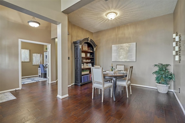 70 Harvest Wind Pl, The Woodlands, TX 77382 - dining space with baseboards, wood finished floors, ornate columns, and a textured ceiling