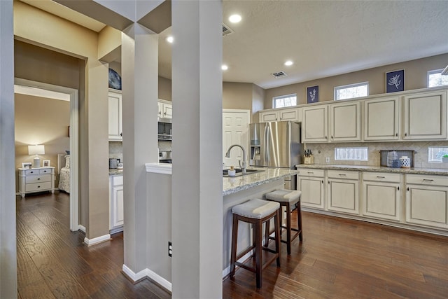 70 Harvest Wind Pl, The Woodlands, TX 77382 - kitchen featuring stainless steel appliances, a sink, decorative backsplash, dark wood-type flooring, and recessed lighting