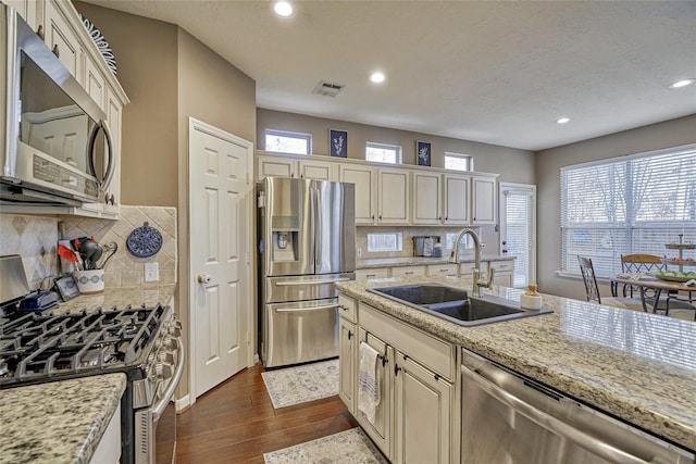 70 Harvest Wind Pl, The Woodlands, TX 77382 - kitchen with appliances with stainless steel finishes, a sink, cream cabinets, and recessed lighting