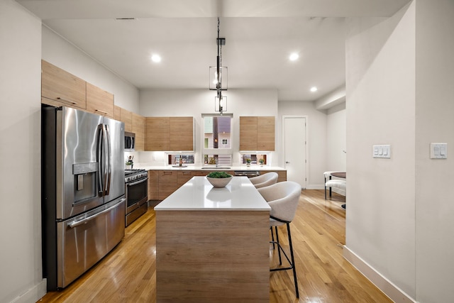 2705 St Emanuel St, Houston, TX 77004 - kitchen featuring appliances with stainless steel finishes, modern cabinets, a center island, a breakfast bar, and recessed lighting