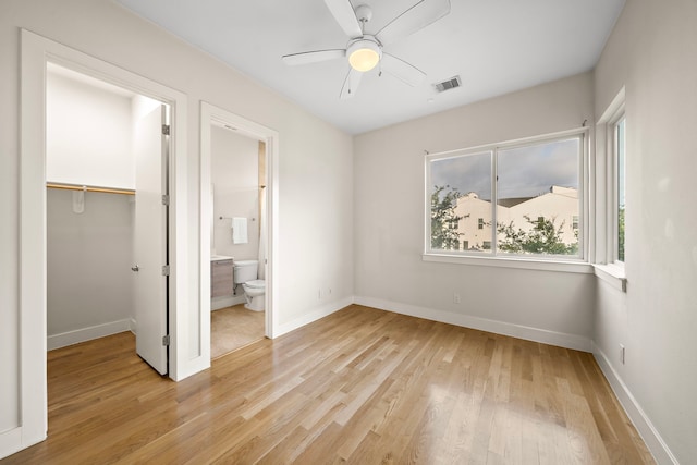 2705 St Emanuel St, Houston, TX 77004 - unfurnished bedroom with light wood-style flooring, a spacious closet, a closet, and baseboards
