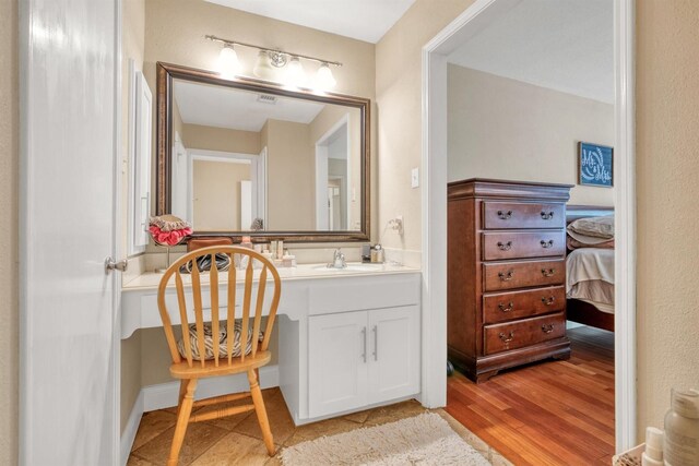 bathroom featuring vanity, ensuite bathroom, and wood finished floors