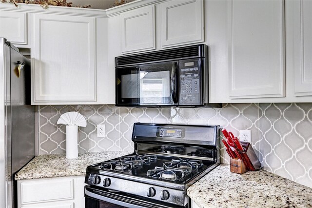 923 Garrett Dr, Magnolia, TX 77354 - kitchen with appliances with stainless steel finishes, decorative backsplash, white cabinets, and light stone countertops