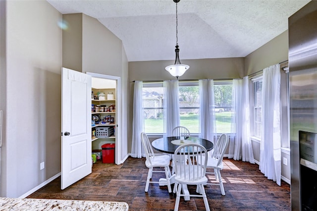 923 Garrett Dr, Magnolia, TX 77354 - dining room with vaulted ceiling, dark wood-style flooring, baseboards, and a textured ceiling