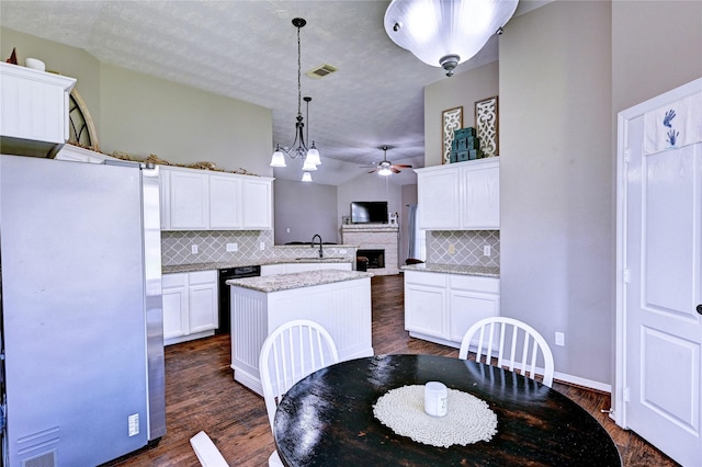 923 Garrett Dr, Magnolia, TX 77354 - kitchen featuring freestanding refrigerator, ceiling fan, decorative backsplash, a kitchen island, and white cabinets