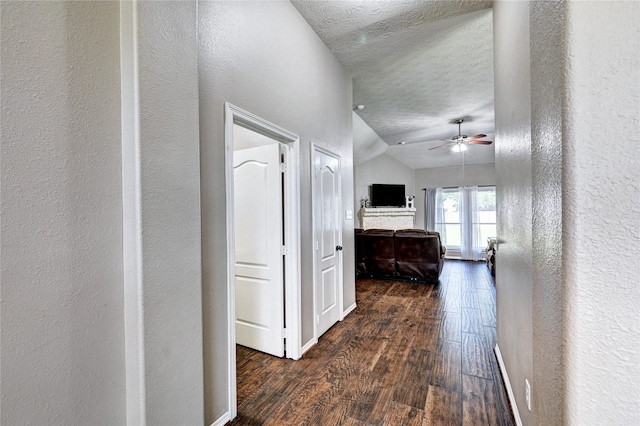923 Garrett Dr, Magnolia, TX 77354 - hall featuring a textured wall, wood finished floors, a textured ceiling, vaulted ceiling, and baseboards