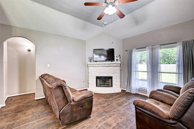 923 Garrett Dr, Magnolia, TX 77354 - living room with arched walkways, wood finished floors, a ceiling fan, a stone fireplace, and vaulted ceiling