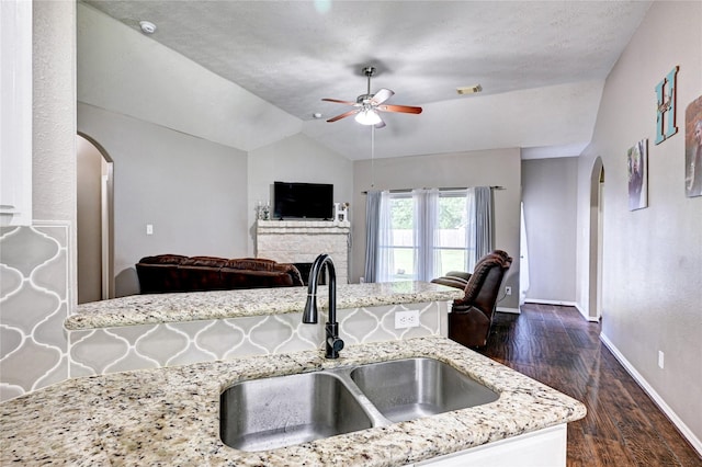 923 Garrett Dr, Magnolia, TX 77354 - kitchen featuring arched walkways, a sink, a ceiling fan, lofted ceiling, and baseboards