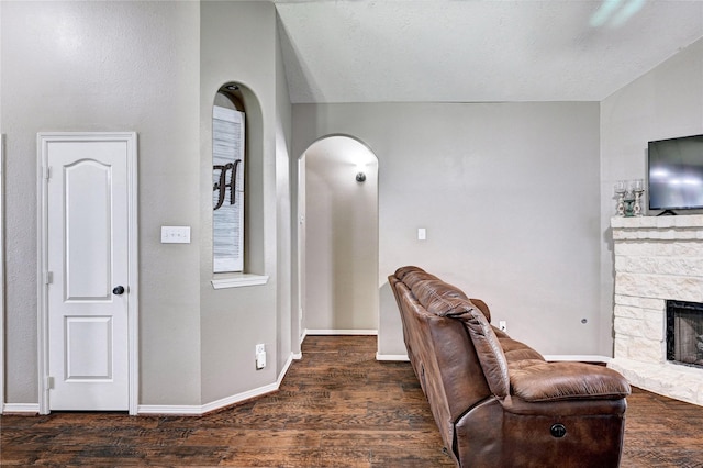 923 Garrett Dr, Magnolia, TX 77354 - living room with arched walkways, wood finished floors, a stone fireplace, and baseboards