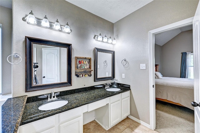 923 Garrett Dr, Magnolia, TX 77354 - ensuite bathroom with a textured wall, double vanity, tile patterned flooring, and baseboards