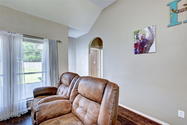 923 Garrett Dr, Magnolia, TX 77354 - living room with arched walkways, lofted ceiling, baseboards, and dark wood-style flooring