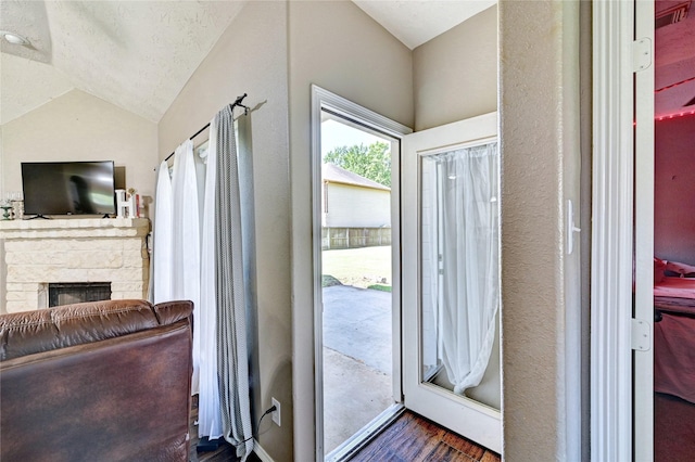 923 Garrett Dr, Magnolia, TX 77354 - entryway featuring vaulted ceiling, dark wood-style floors, a fireplace, and baseboards