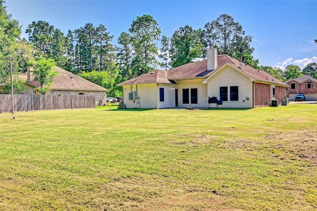 923 Garrett Dr, Magnolia, TX 77354 - back of house with central air condition unit and a chimney