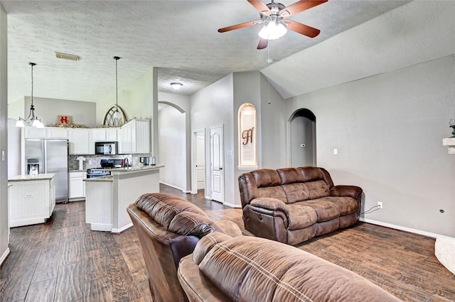 923 Garrett Dr, Magnolia, TX 77354 - living room featuring arched walkways, dark wood-type flooring, a ceiling fan, baseboards, and high vaulted ceiling