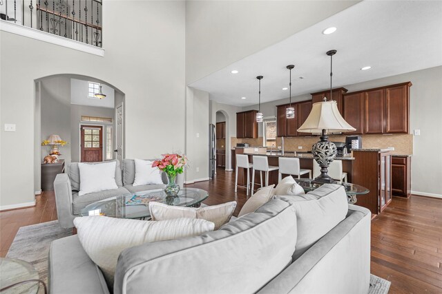 22726 Little Blue Stem Dr, Tomball, TX 77375 - living room featuring arched walkways, healthy amount of natural light, baseboards, dark wood-type flooring, and recessed lighting