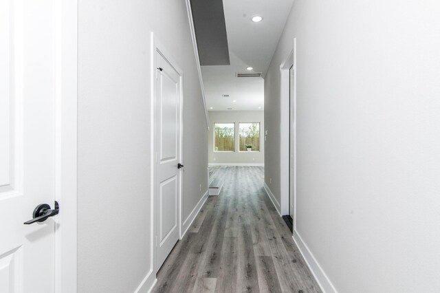 corridor with light wood-style flooring, recessed lighting, and baseboards