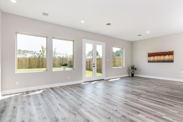 unfurnished living room featuring french doors, recessed lighting, wood finished floors, and baseboards