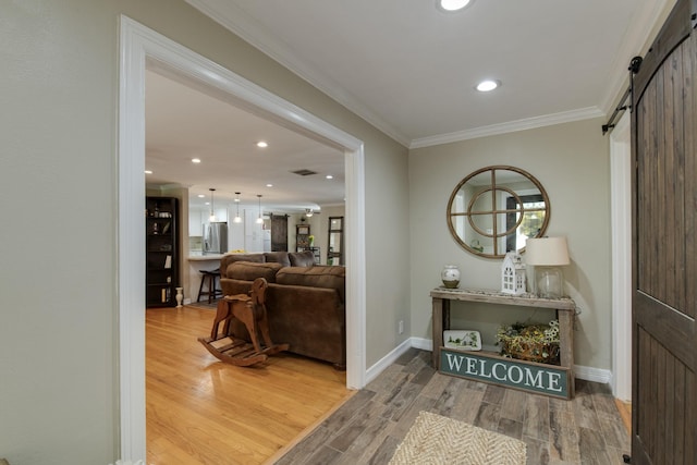11107 Atwell Dr, Houston, TX 77096 - entryway featuring a barn door, wood finished floors, ornamental molding, recessed lighting, and baseboards