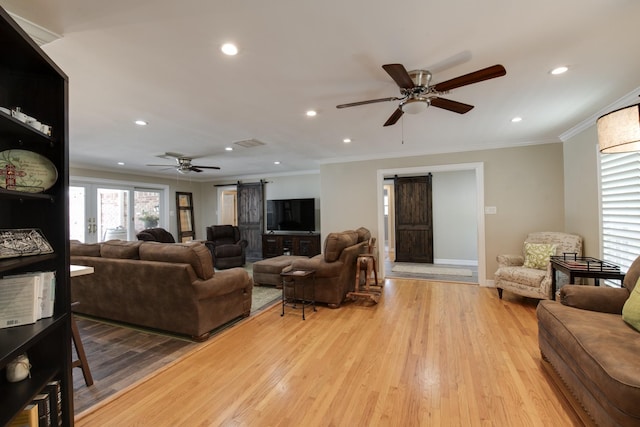 11107 Atwell Dr, Houston, TX 77096 - living area with a barn door, ceiling fan, ornamental molding, light wood-style floors, and recessed lighting