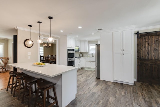 11107 Atwell Dr, Houston, TX 77096 - kitchen with stainless steel appliances, crown molding, dark wood-style flooring, a kitchen breakfast bar, and a peninsula