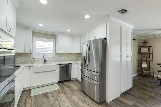 11107 Atwell Dr, Houston, TX 77096 - kitchen with appliances with stainless steel finishes, a sink, backsplash, crown molding, and light countertops