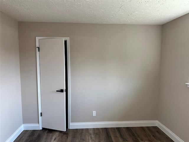 402 Boone Ct, Deer Park, TX 77536 - spare room featuring dark wood-type flooring, baseboards, and a textured ceiling