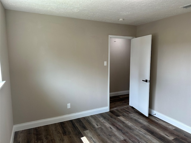 402 Boone Ct, Deer Park, TX 77536 - unfurnished room with dark wood-type flooring, a textured ceiling, and baseboards