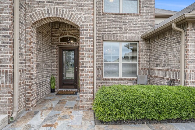 view of exterior entry with brick siding