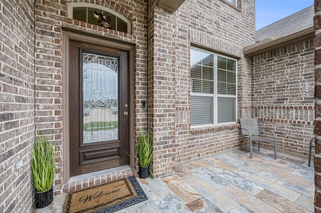 doorway to property with brick siding