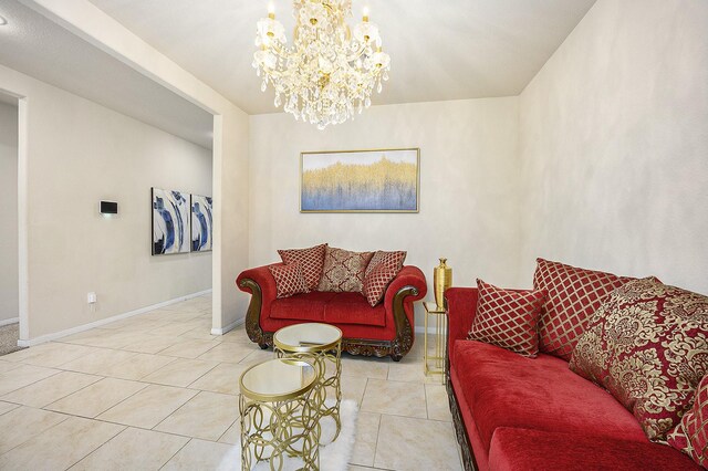 tiled living room featuring a chandelier and baseboards