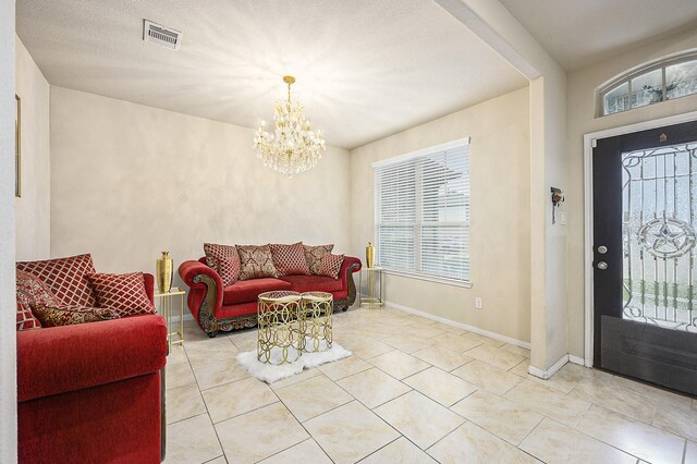 tiled foyer entrance with a chandelier and baseboards