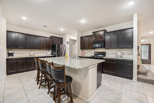 kitchen with black appliances, decorative backsplash, a sink, light tile patterned floors, and recessed lighting