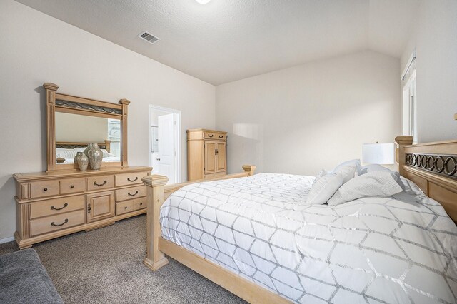 bedroom featuring carpet flooring, lofted ceiling, baseboards, and ensuite bath