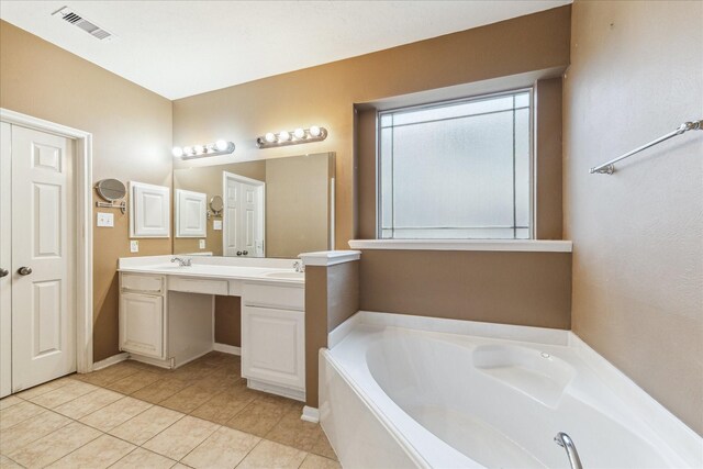 bathroom featuring a garden tub, double vanity, and tile patterned flooring