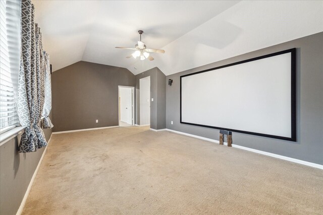 home theater room with a ceiling fan, lofted ceiling, carpet, and baseboards