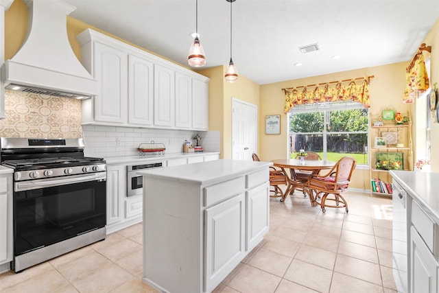 kitchen featuring appliances with stainless steel finishes, custom exhaust hood, light countertops, light tile patterned flooring, and white cabinetry