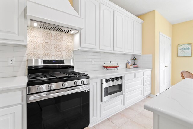 kitchen with stainless steel appliances, premium range hood, decorative backsplash, and white cabinets