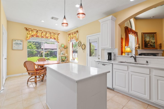 kitchen with a sink, dishwasher, a kitchen island, light countertops, and recessed lighting