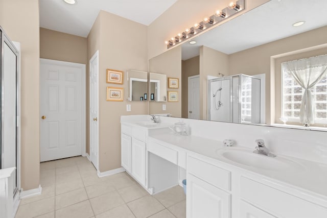 bathroom featuring tile patterned floors, a shower stall, baseboards, and double vanity