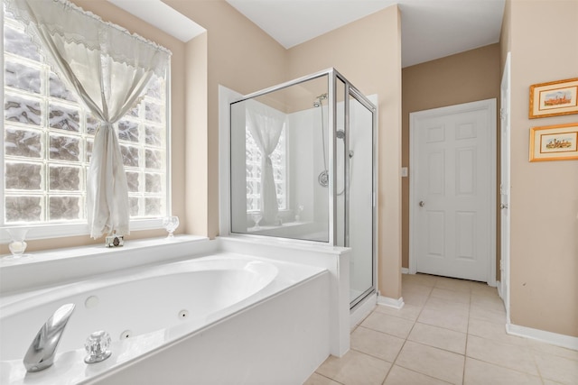 bathroom with tile patterned floors, a tub with jets, a stall shower, and baseboards