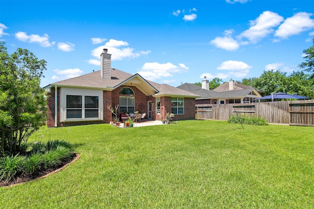 rear view of property with a patio, brick siding, a chimney, and roof with shingles