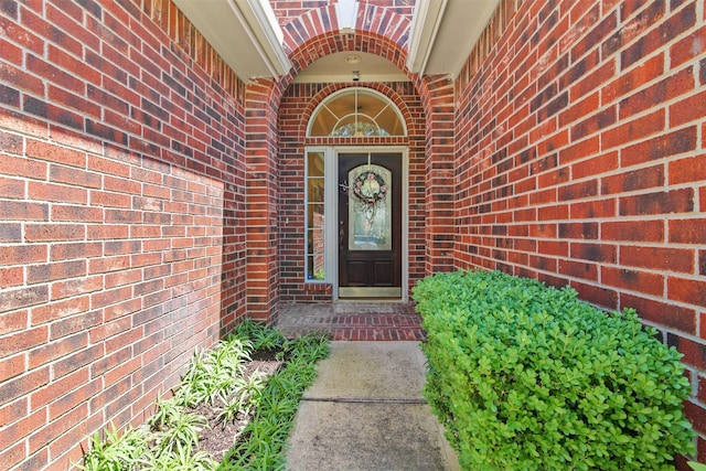 view of exterior entry with brick siding